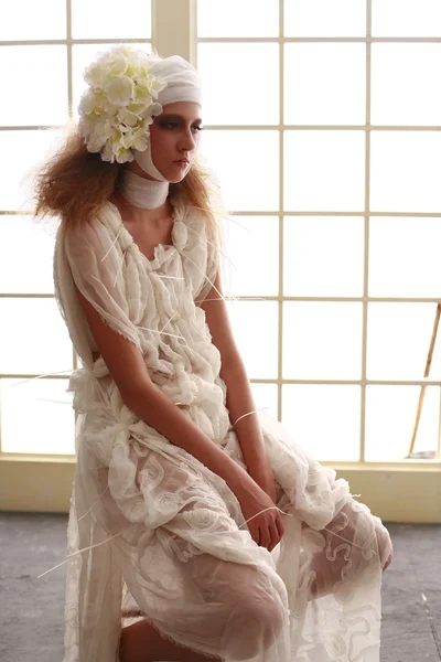 genç, kırılgan kız başını sargılı, bir elbise içinde ayakta hasta