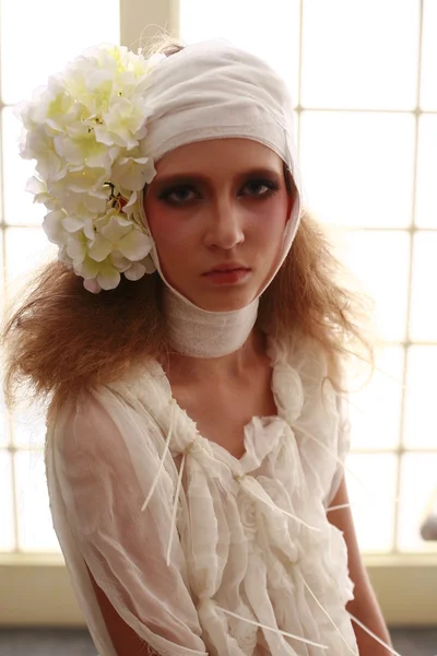 genç, kırılgan kız başını sargılı, bir elbise içinde ayakta hasta