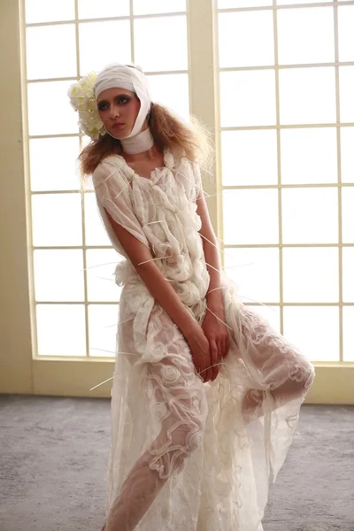 genç, kırılgan kız başını sargılı, bir elbise içinde ayakta hasta