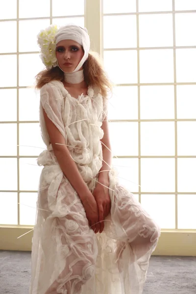 genç, kırılgan kız başını sargılı, bir elbise içinde ayakta hasta