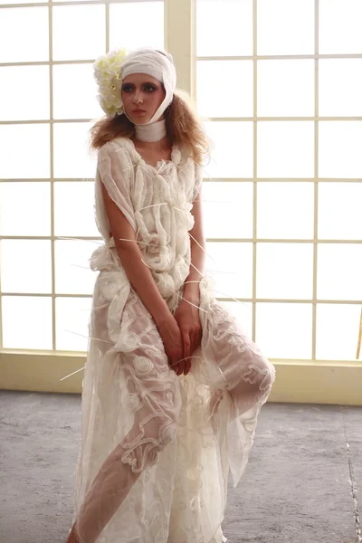 genç, kırılgan kız başını sargılı, bir elbise içinde ayakta hasta