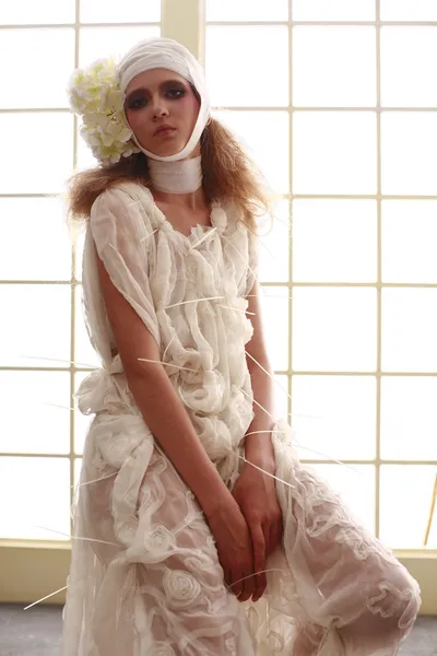 genç, kırılgan kız başını sargılı, bir elbise içinde ayakta hasta