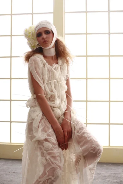 genç, kırılgan kız başını sargılı, bir elbise içinde ayakta hasta