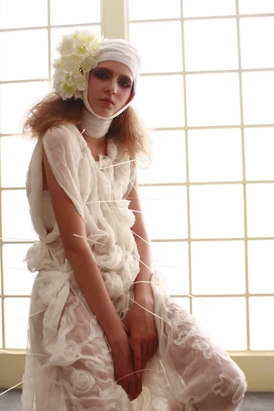 genç, kırılgan kız başını sargılı, bir elbise içinde ayakta hasta