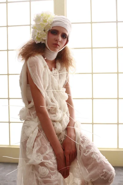 genç, kırılgan kız başını sargılı, bir elbise içinde ayakta hasta