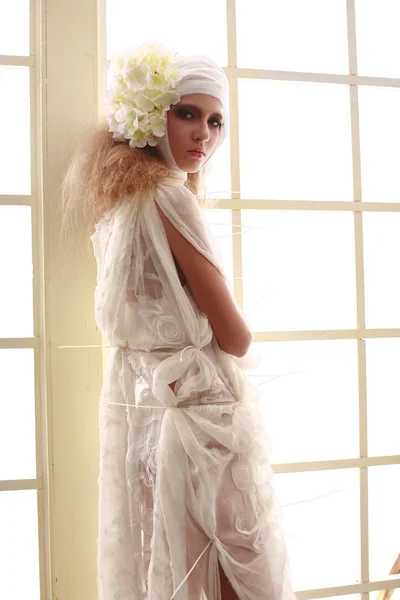 genç, kırılgan kız başını sargılı, bir elbise içinde ayakta hasta