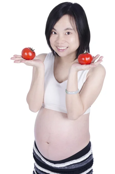 Beautiful pregnant woman holding fresh tomato by hand isolated over white background — Stock Photo, Image