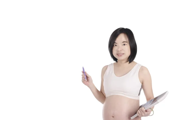 Pregnant woman is writing and reading with white background — Stock Photo, Image