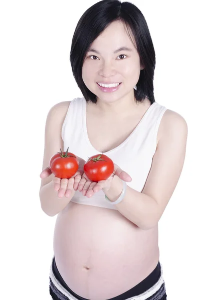 Schöne schwangere Frau hält frische Tomaten von Hand isoliert über weißem Hintergrund — Stockfoto
