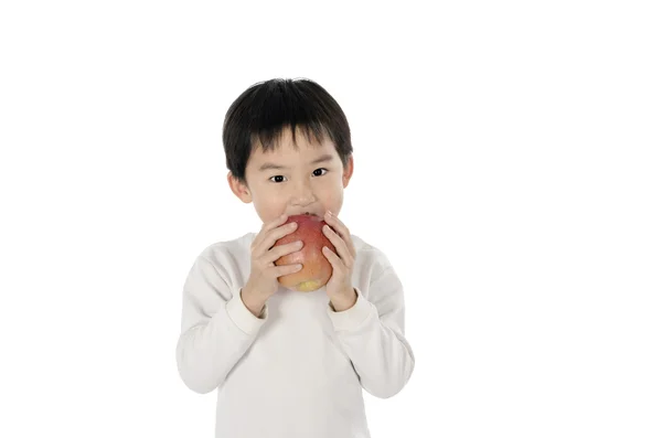吃一个苹果的可爱小男孩 图库图片