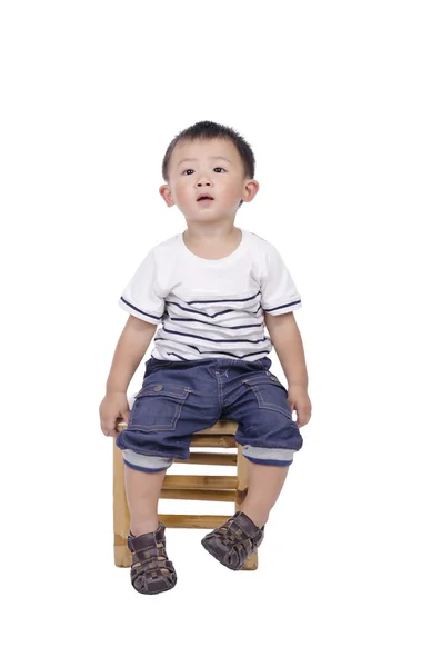 Süße asiatische Junge sitzt auf Bambushockern — Stockfoto