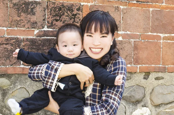 Mother and son stand in front of wall — Stock Photo, Image