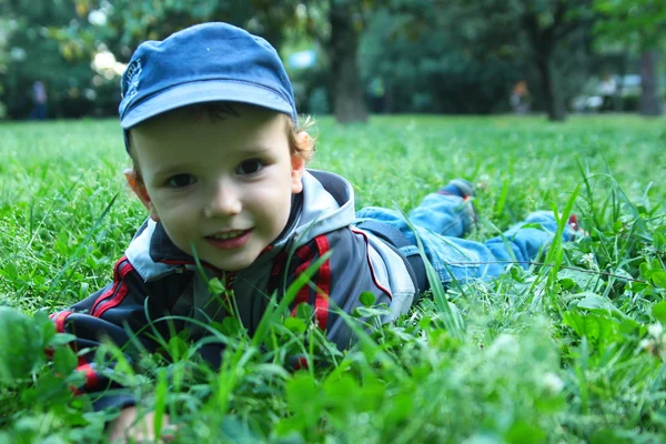 De jongen in een gras — Stockfoto