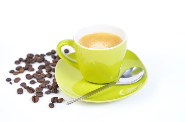 Yeşil espresso fincan kahve çekirdekleri ve 3 kaşık ile