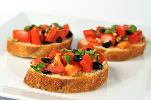 Bruschetta su piatto bianco primo piano — Foto Stock