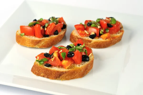 Tradiční bruschetta na bílé desce — Stock fotografie