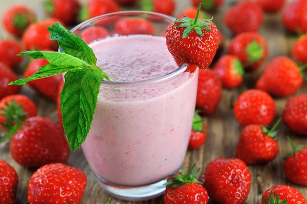 Erdbeer-Milchshake und viele Erdbeeren lizenzfreie Stockfotos