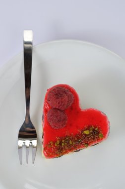 tarte beyaz tabakta meyveli kalp şeklinde