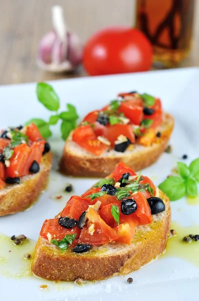 Bruschetta with oil on wooden table and white plate — Stock Photo, Image