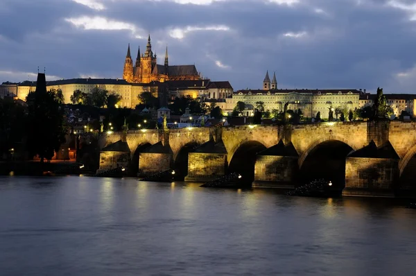 The illuminated charles bridge and the prague castle at evening — Stock Photo, Image