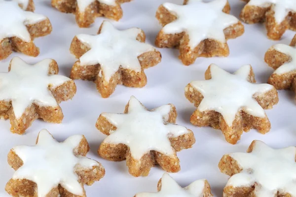 Many cinnamon stars against white background from the side — Stock Photo, Image