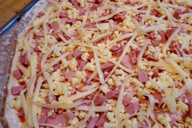 Pişmemiş jambon, sosis ve peynirli pizza.