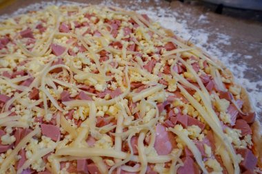 Pişmemiş jambon, sosis ve peynirli pizza.