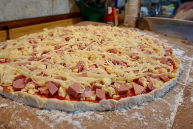 Pişmemiş jambon, sosis ve peynirli pizza.