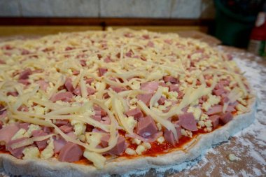 Pişmemiş jambon, sosis ve peynirli pizza.