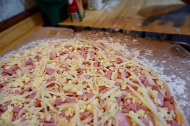 Pişmemiş jambon, sosis ve peynirli pizza.
