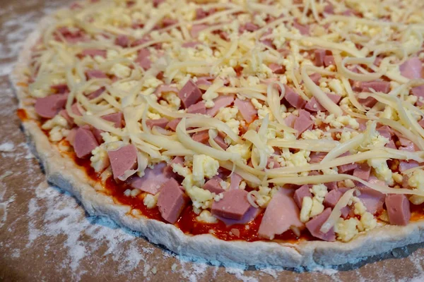 Pişmemiş jambon, sosis ve peynirli pizza.