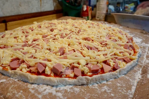 Pişmemiş jambon, sosis ve peynirli pizza.