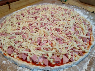 Pişmemiş jambon, sosis ve peynirli pizza.