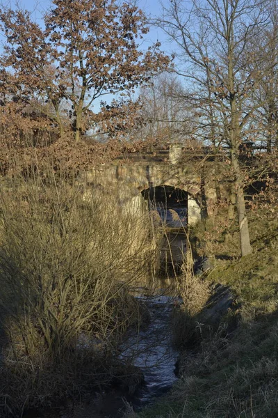 早春在一条被忽视的小河上的神秘石桥 — 图库照片