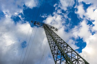 Bulutlu gökyüzünün altında elektrik direği