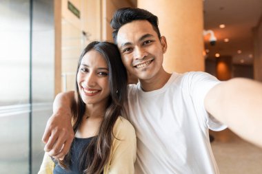 Genç bir çift kameraya gülümsüyor.