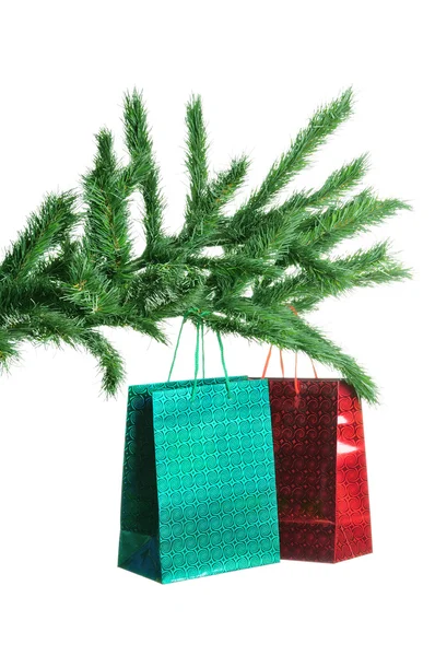 Rama de pino y bolsas de regalo aisladas sobre fondo blanco —  Fotos de Stock