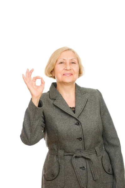 Portret van een glimlachende senior zakenvrouw weergegeven: Oke symbool geïsoleerd op witte achtergrond — Stockfoto