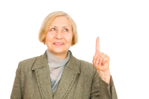 Portrait of a happy senior woman pointing upwards isolated on white background — Stock Photo, Image