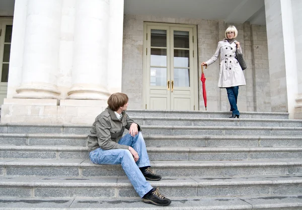 Mężczyzna siedzący na schodach i patrzy na kobietę — Zdjęcie stockowe
