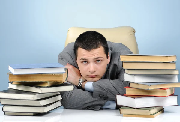 Κουρασμένος επιχειρηματίας στα βιβλία σε γκρι φόντο — Φωτογραφία Αρχείου
