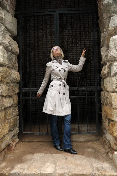 Portrait de mode de jeune femme attrayante regardant vers le haut près du mur de pierre — Photo