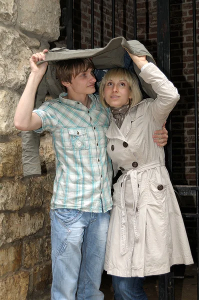 Couple in a rainy day hiding from rain — Stock Photo, Image