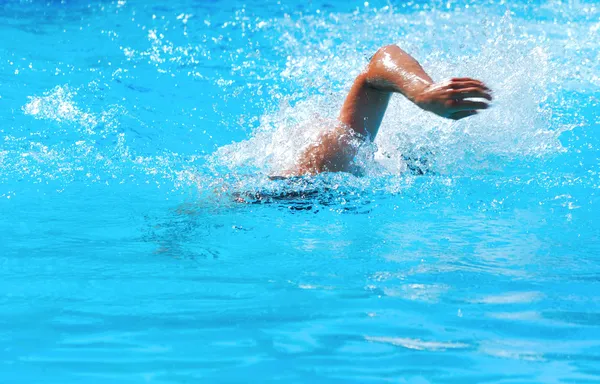 Young man swimming the front crawl in a pool — Stock Photo, Image