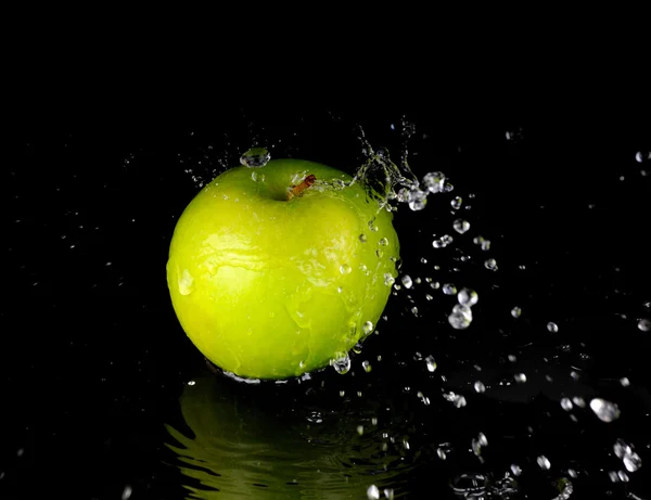 Salpicos de água doce na maçã verde no fundo preto — Fotografia de Stock