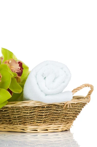 Piękny storczyk zielony i ręcznik w koszyku słomy na białym tle — Zdjęcie stockowe