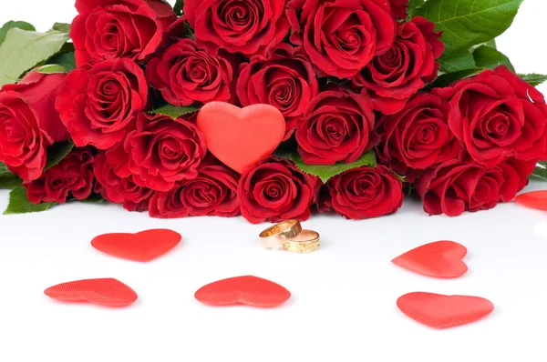 Rote Rosen und zwei goldene Eheringe — Stockfoto