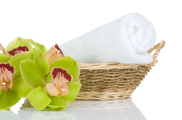Piękny storczyk zielony i ręcznik w koszyku słomy na białym tle — Zdjęcie stockowe