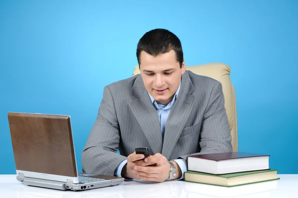 Empresario en el trabajo sobre fondo azul — Foto de Stock