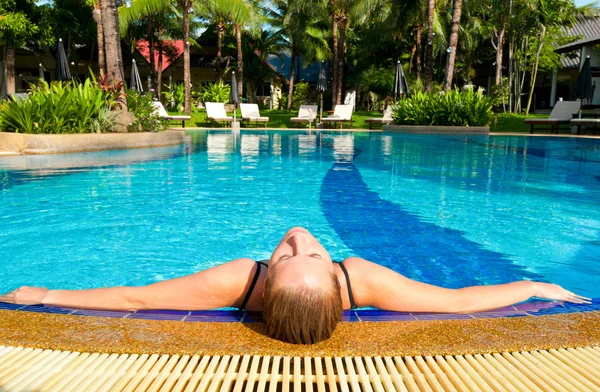 Vrouw ontspannen in het zwembad — Stockfoto